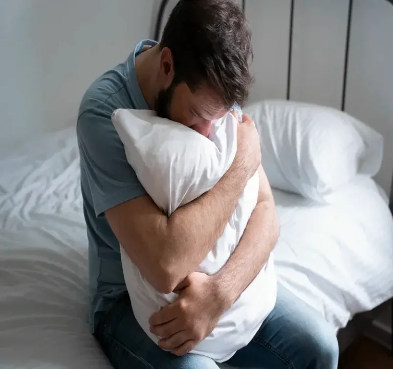 side-view-anxious-man-hugging-pillow